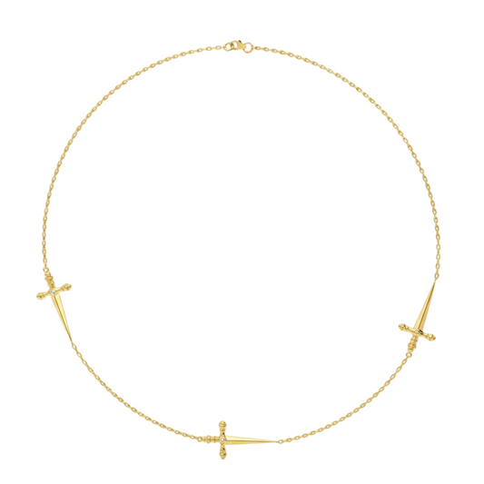 Gold necklace with three small sword pendants on a white background